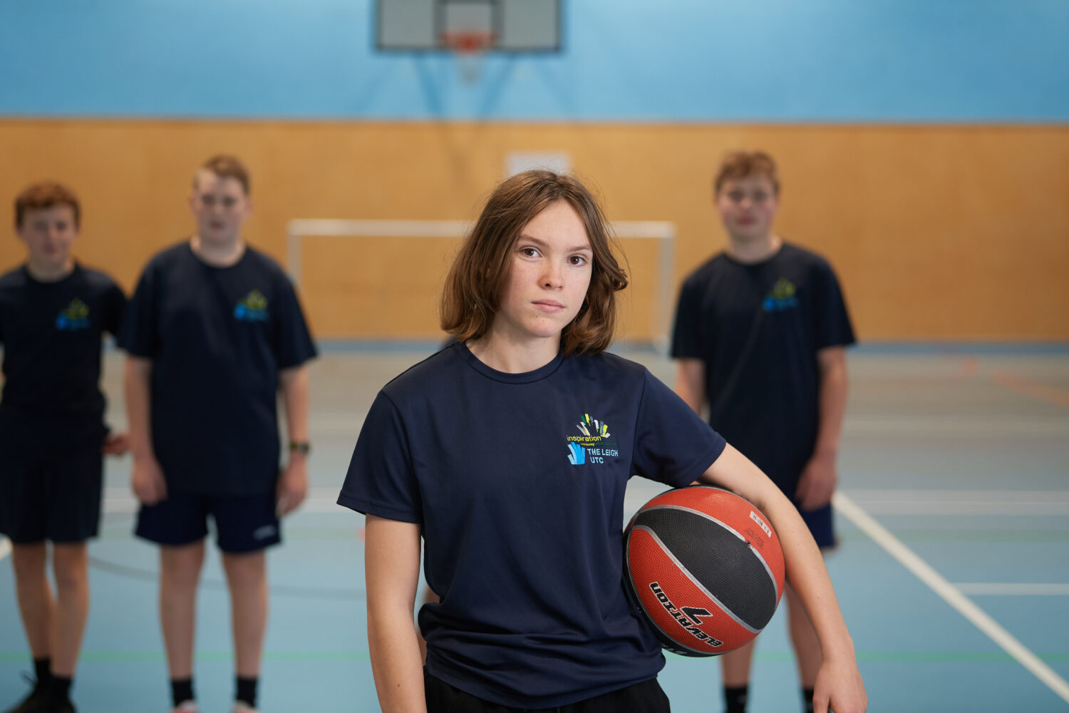 Four Inspiration Academy students are pictured posing for the camera, whilst playing a game of Basketball together in the Sports Hall.