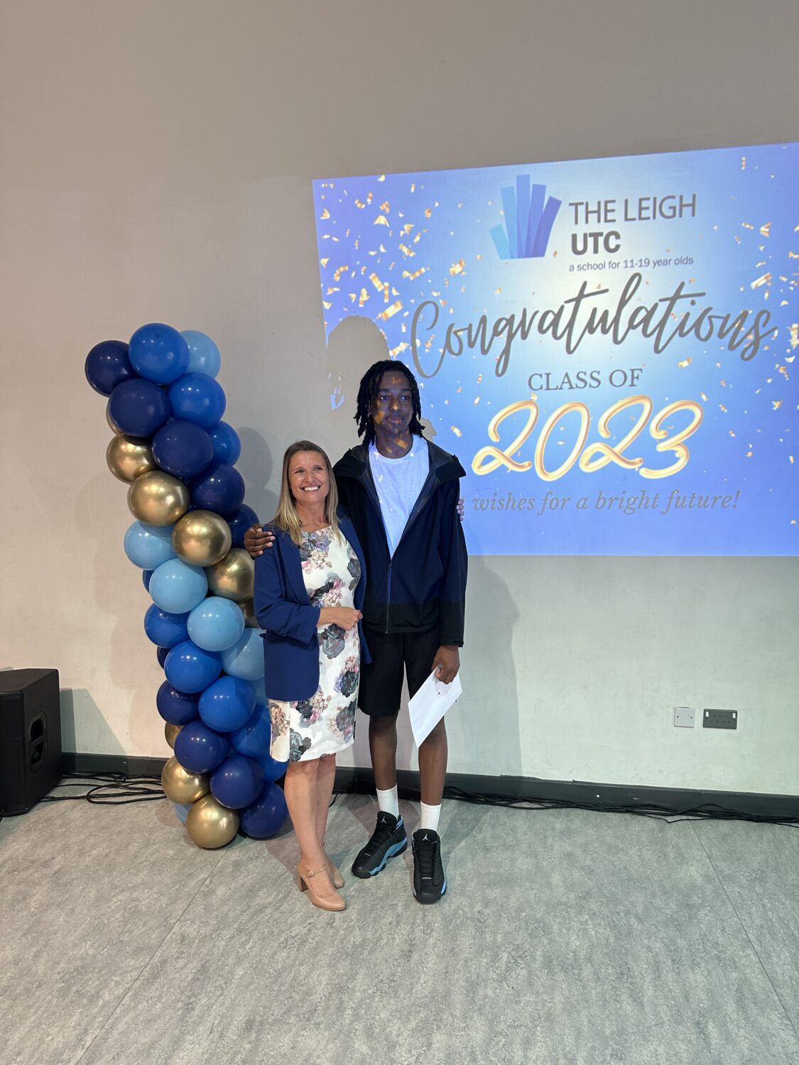 Ivan stood with a staff member holding their results