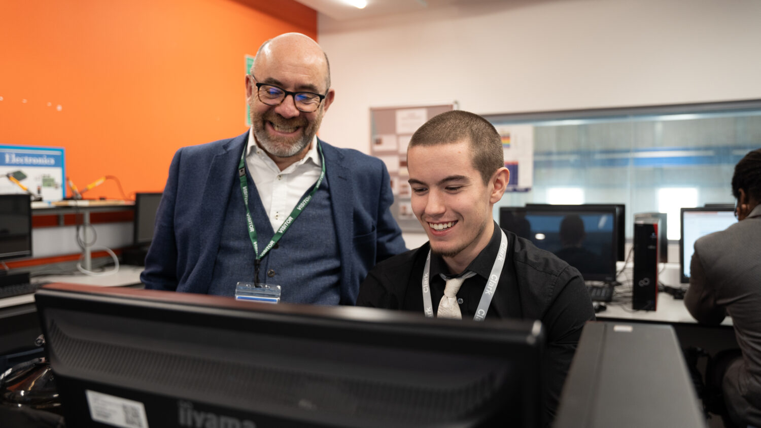 Labour minster looking at a computer with a student