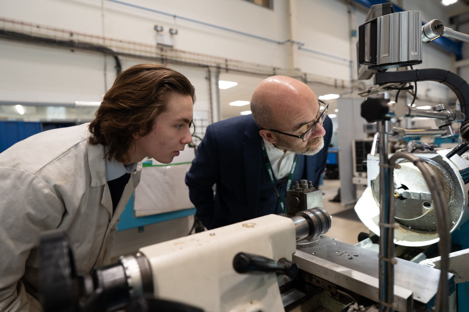 Labour minster looking at a machine with a student