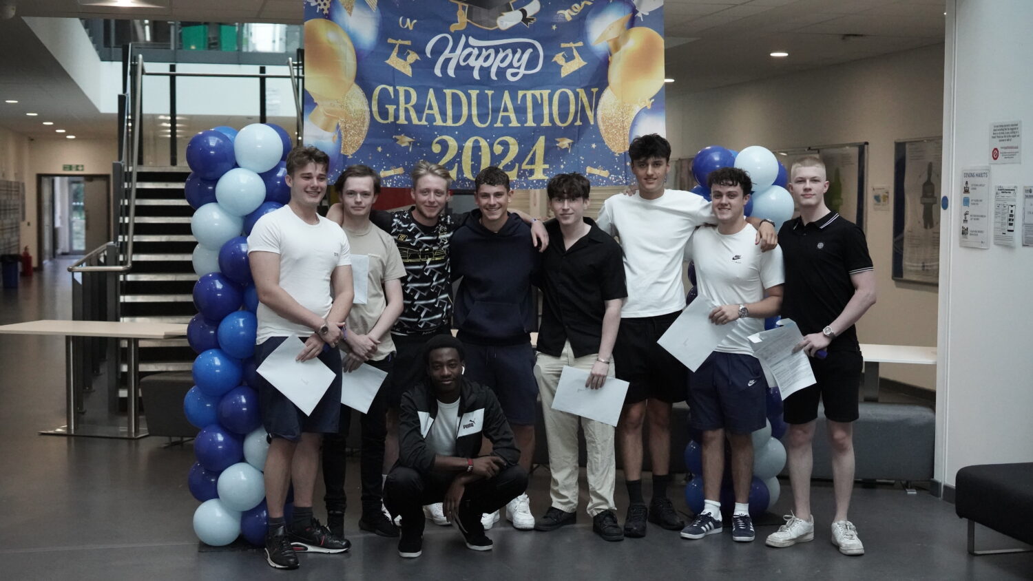 A group of Post-16 students are pictured smiling together for the camera, after having just received their A-Level results.