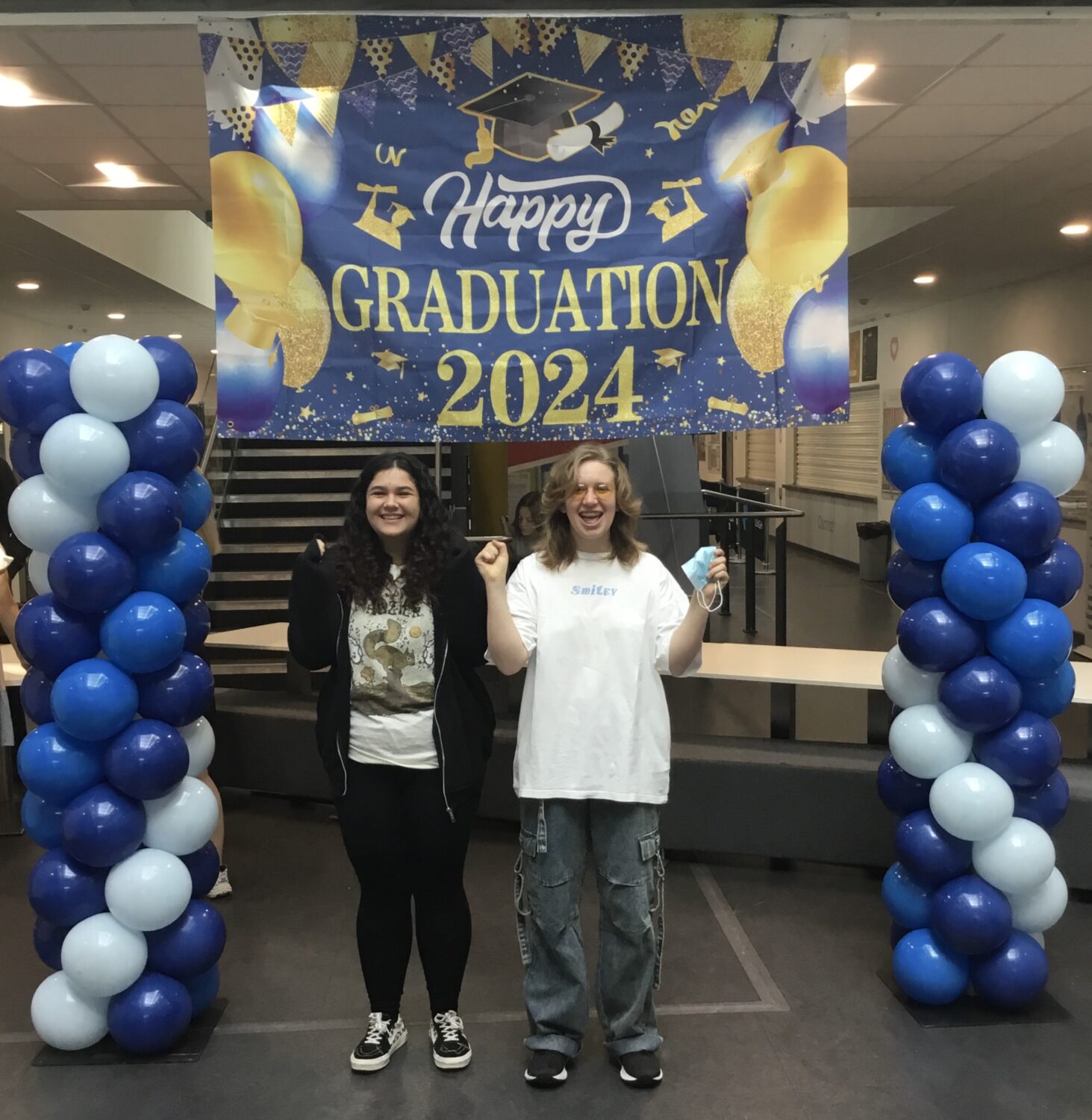 Two female Post-16 students are pictured smiling together for the camera, after having just opened their A-Level results.
