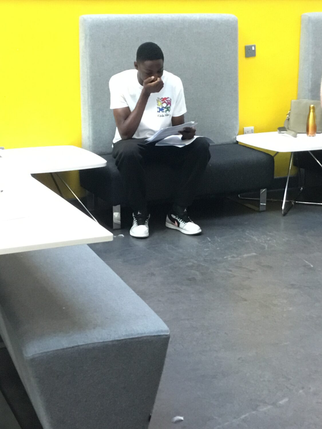 A male Post-16 student is pictured with his hand over his mouth in surprise as he looks at his A-Level results.