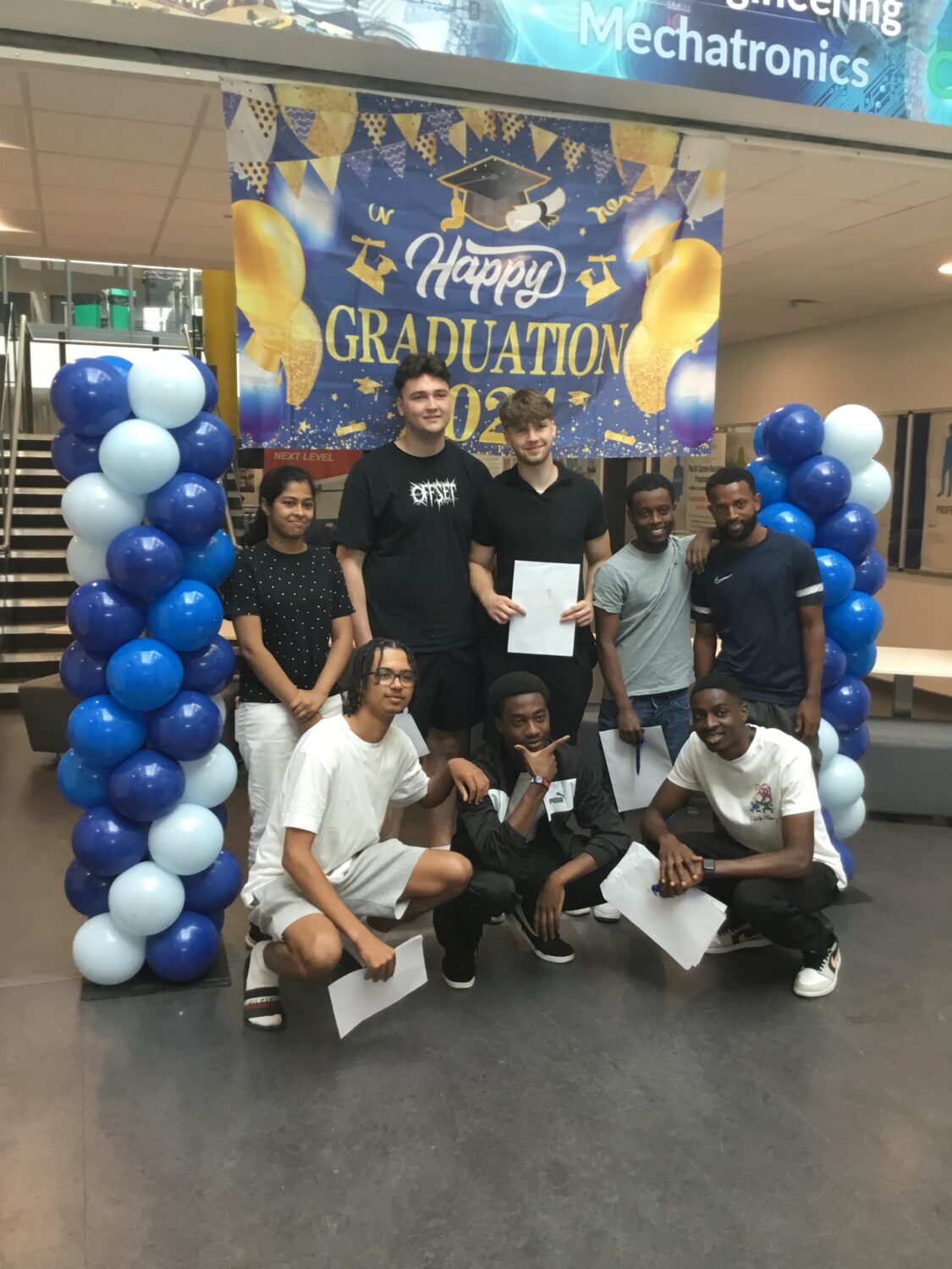 A group of Post-16 students are pictured smiling together for the camera, after having just received their A-Level results.